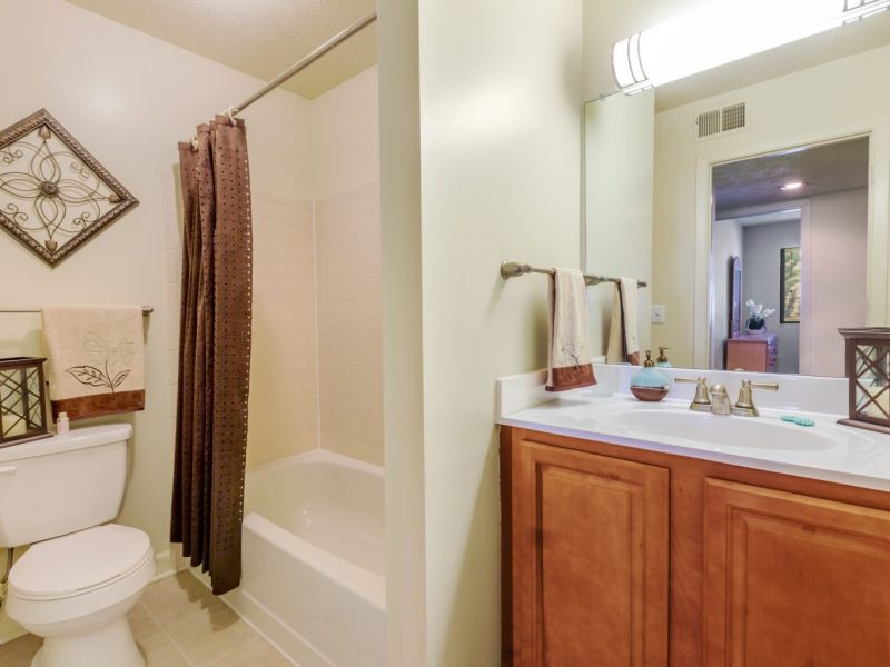 This image shows the bathroom area featuring the modern brushed nickel fixtures and a shower curtain for the bathtub.